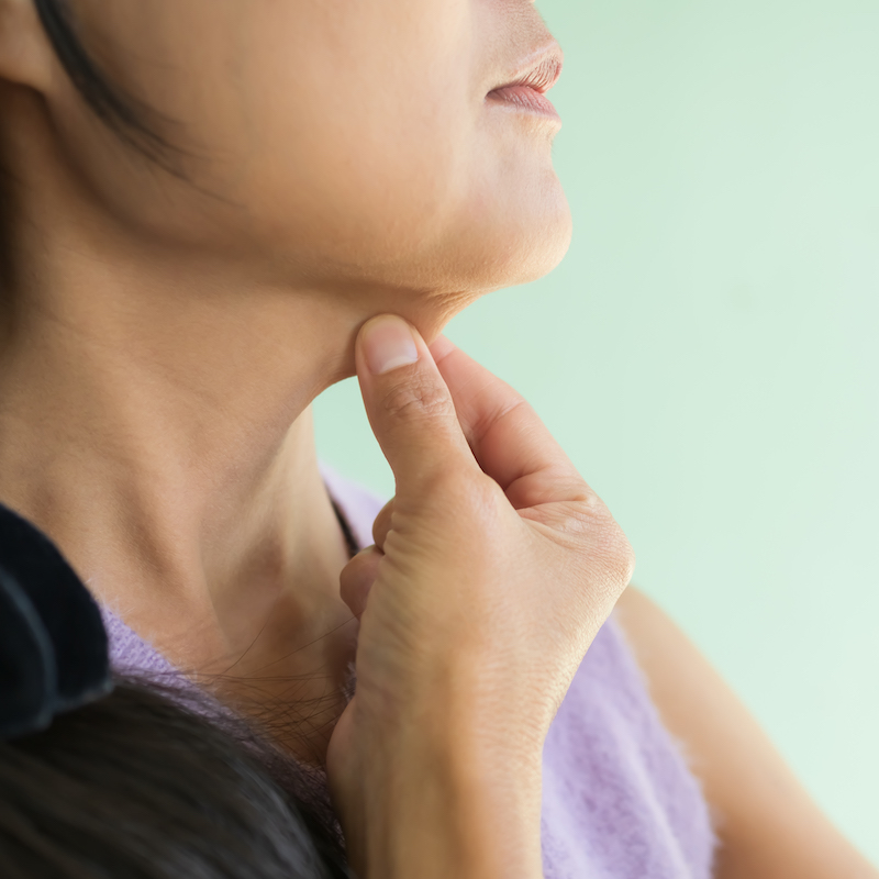 women pinching layer fat under chin on green wall 2026 01 08 02 40 19 utc